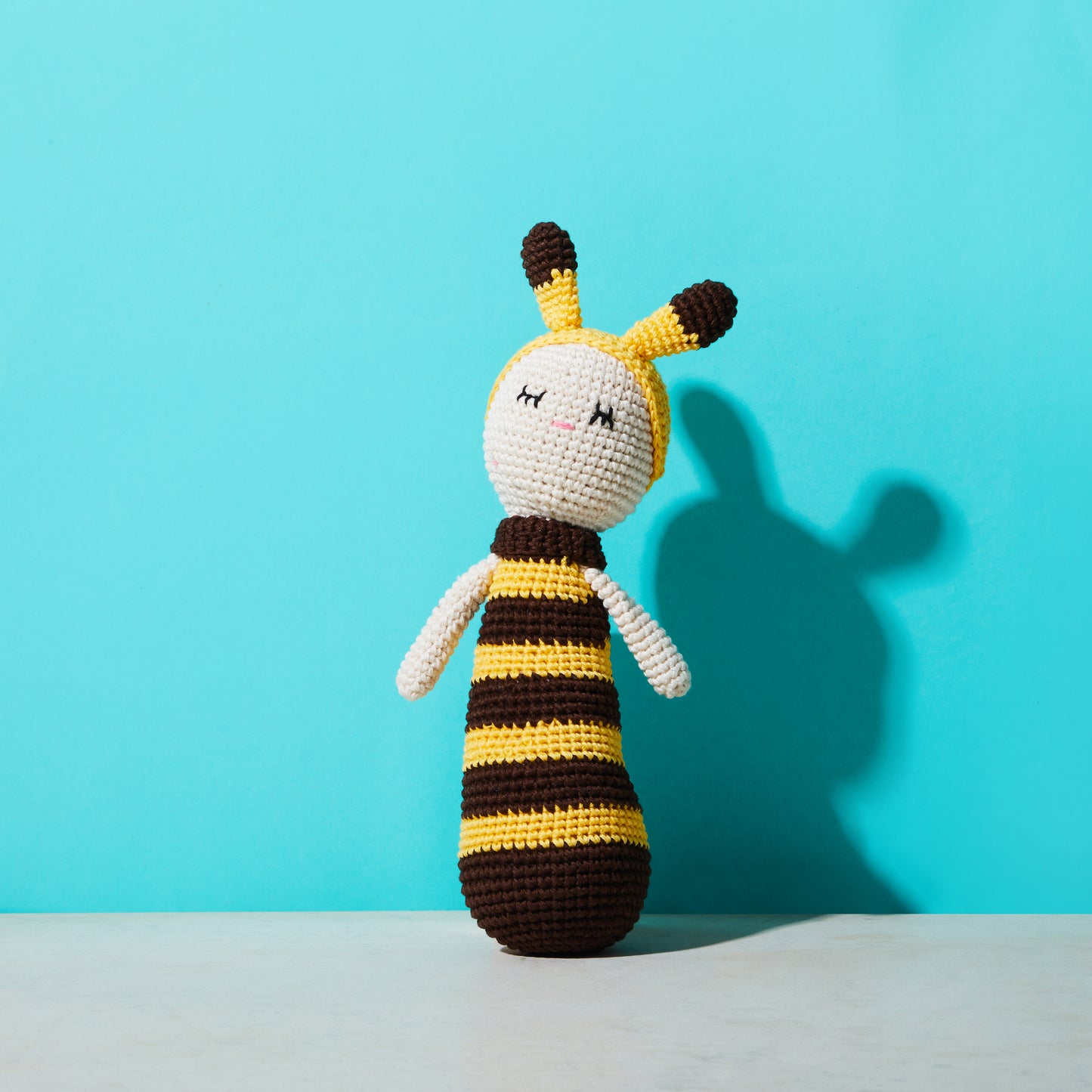 Crochet toy, sleeping bee, front view with shadow